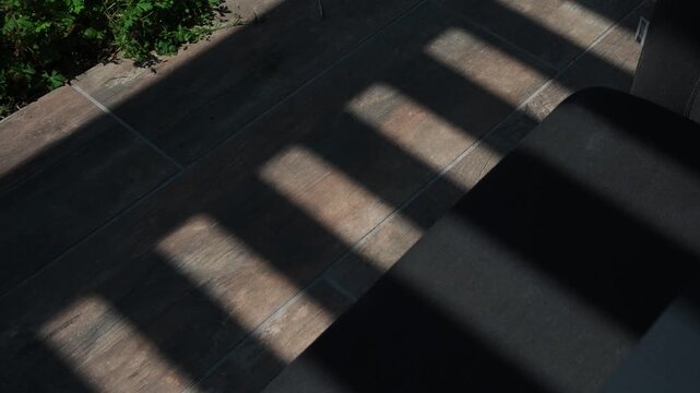 Modern pergola casting dramatic shadows on a sunny day, evoking tranquility