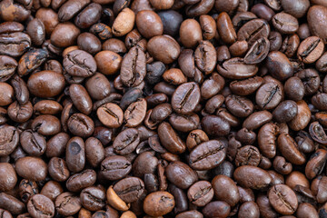 Rustic surface with diverse bean hues, Natural oils and rich aroma highlight quality beans, Closeup of carefully chosen coffee beans showcasing color and aromatic appeal