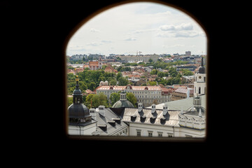 Historic buildings among green trees in a European city. A panoramic bird's-eye view of the historic city from the window of a tall old castle. June 1, 2025, Vilnius, Lithuania.