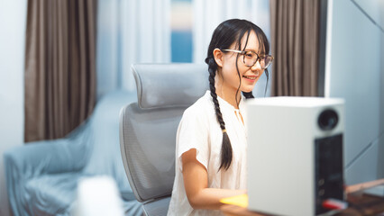 Young adult asian woman gen z freelance using desktop computer upskill tech assistance ai chatbot at home office