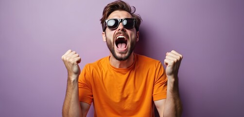 Young crazy man shouts with mouth wide open celebrating success. Bearded guy in sunglasses clenches fists expressing anger joy. Emotional male model screams with excitement against plain purple