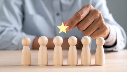 Hand placing yellow star above wooden figurine, symbolizing recognition, evaluation, and standout performance.