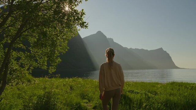 Person enjoying sunrise over Senja, Norway, capturing tranquil beauty