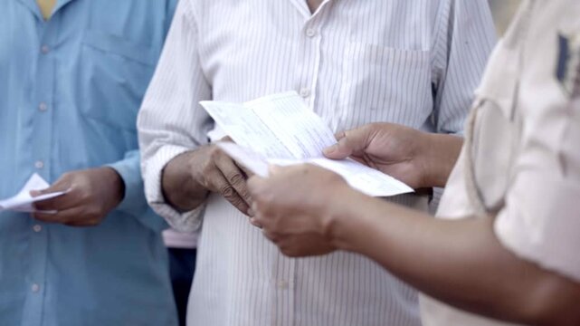 Police personnel checking and verifying voter id card of voter during Bihar assembly election