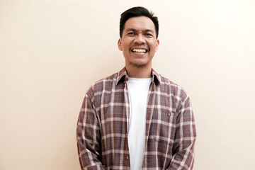 Southeast Asian man wearing flannel shirt standing and smiling expression happy, on white isolated background