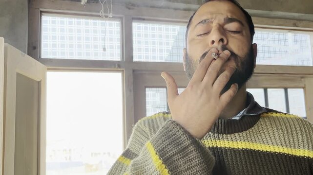 Young boy weed addictive man coughing while smoking a marijuana cigarette. Young boy coughing heavily while burning a cigarette or smoking a weed cigrette. Tobacco causes cancer concept. Stop smoking.