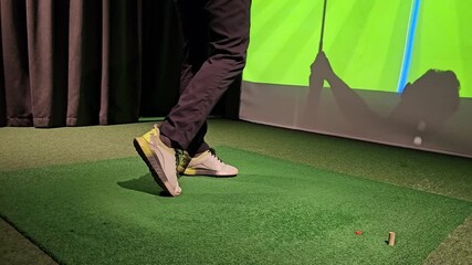 Golf practice session indoors with a focus on putting using a simulator