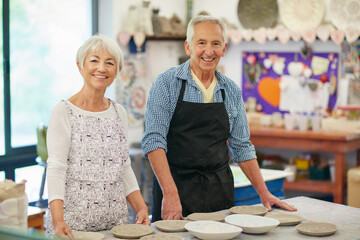 Creative, old couple and portrait in workshop, pottery and skills for production, teamwork and clay. Small business, elderly man and senior woman with sculpture, craftsmanship and ceramic product