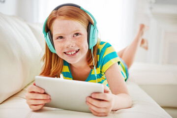 Headphones, tablet and relax with girl on sofa of home for streaming service, cartoon app and search. Online movie subscription, mulitmedia and games with child in living room of apartment for music