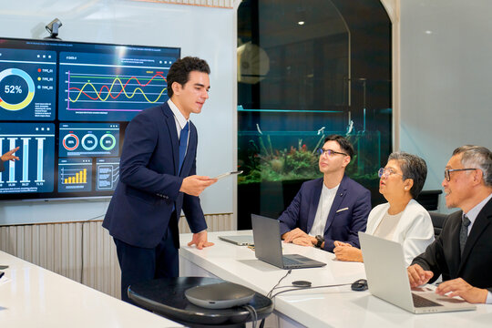 Businessman lead the meeting in meeting room with team of senior sales and other.