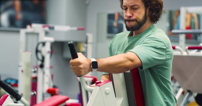 Cropped 4k footage of a Caucasian man working out in the gym. Workout for back muscles. Physical education as a norm of life for maintaining health.