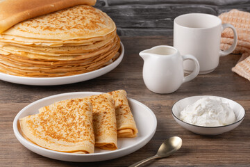 Traditional Russian pancakes with sour cream on a wooden table. Homemade russian thin pancakes blini. Russian food, russian kitchen