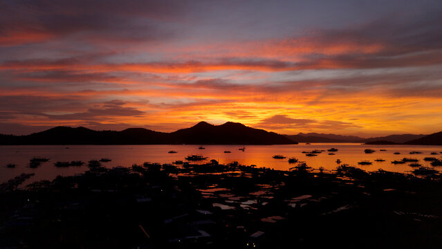 Fiery sunset over Coron harbor with anchored bangka boats