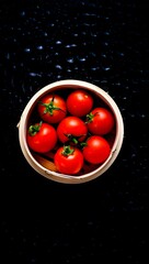 Fresh tomatoes in a bowl on a dark background ready to be eaten or used in cooking now