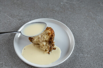 Traditional sweet dumpling dessert and a spoonful of vanilla cream sauce, monkey bread