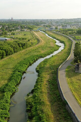 Cycling road by river through lush landscape