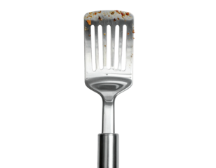 Close-up of a well-used silver spatula with food remnants, against a solid black backdrop