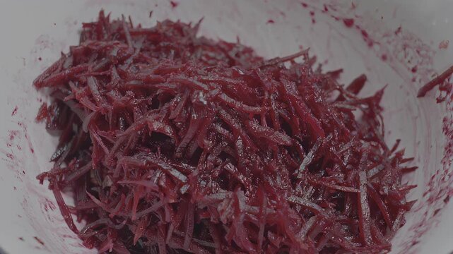 Grated red root vegetable in white bowl
