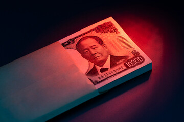 日本円の高額紙幣が封筒から覗く資金や取引のイメージ