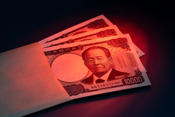 封筒からのぞく一万円札束が象徴する高額資金と金融イメージ