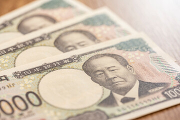 木目テーブルに並べた一万円札が示す日本円の高額現金イメージ