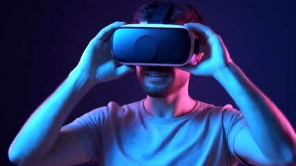 Excited young male engaging with virtual reality headset experiencing immersive digital world, exploring metaverse and future technology - Powered by Adobe