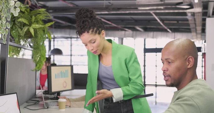 Walking between desks at office, diverse coworkers discussing bar and pie charts to align goals