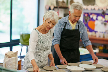 Teamwork, old couple and handcraft in workshop, pottery and skills for production or art inspection. Small business, elderly man and senior woman with sculpture, craftsmanship and ceramic product