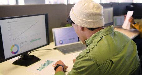 Data analyst spotting growth charts and studying bar chart at desk while colleagues typing pointing - Powered by Adobe