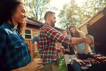 Happy, talking and friends in backyard with barbecue for social gathering, hangout and bonding on weekend. Party, outdoor and people with alcohol, food and fire for celebration, lunch or relax at bbq