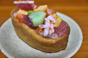 Mixed seafood inarizushi (shrimp, tuna, salmon and dashimaki) purchased at a supermarket in Tokyo, Japan