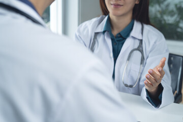 Asian medical doctor colleague working together on patient illness information. Two doctor working...
