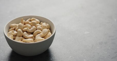 cashew nuts in white bowl on terrazzo countertop