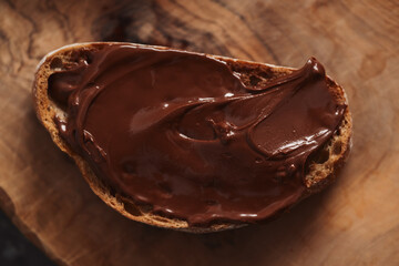 Ciabatta slices with chocolate spread on olive wood board