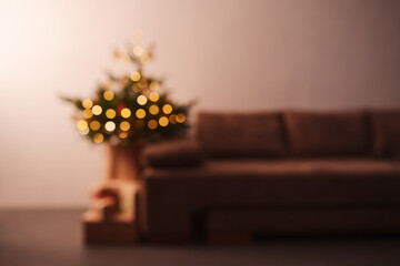 Blurre background of room with illuminating christmas tree in the evening