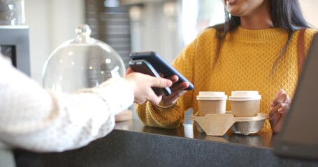 as payment terminal extending at counter Indian woman scanning smartphone picking cups, copy space - Powered by Adobe