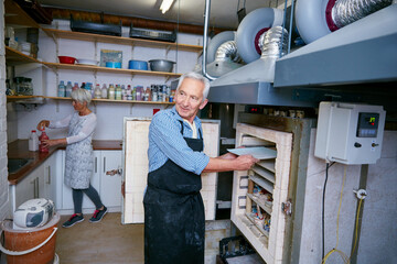 Ceramic, process and old people in workshop with oven, skills or creative hobby in retirement. Preparation, art and man in studio with kiln, production or sculpture craft in senior activity.