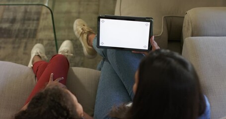 African American mother and daughter adjusting tablet angle on couch to view blank screen - Powered by Adobe