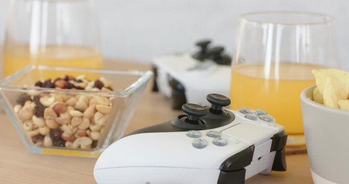 At recording start, camera is alternating focus between game controller and snacks on wood tabletop