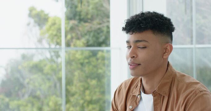 Adult man gazing out window at green trees gathering thoughts then smiling at camera, copy space
