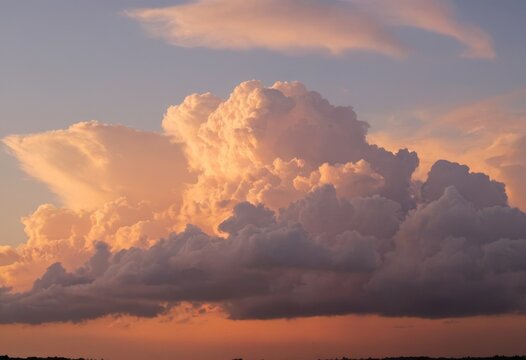 Huge cumulonimbus cloud illuminated by the sunset - Powered by Adobe