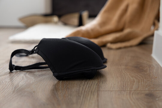 A black bra thrown on the bedroom floor next to the bed, lovers caught cheating,
