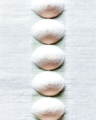 White Wool Balls Arranged on Textured Fabric
