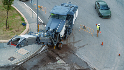 Heavy road milling machine removing old asphalt pavement from a city street © Floren Horcajo