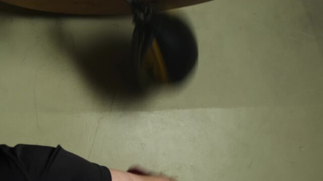 Male boxer practices punching skills on small speed bag. Professional conducts training session in special gym developing concentration and attention