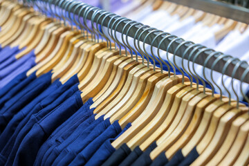 Fototapeta premium Colorful shirts hang on hangers in a clothing store, ready for sale.