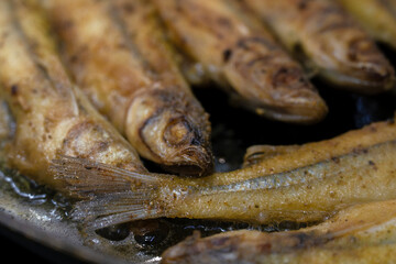 frying fish in a frying pan, smelt in breadcrumbs during roasting, fried delicious beautiful fish