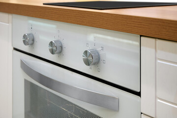 Close up of control panel with knobs for gas stove in home kitchen.