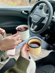 Two young girls on the road. Breakfast on the road. Hot tea in the car. Traveling in winter.