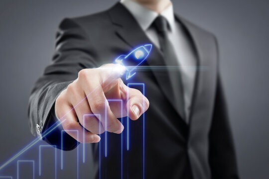 Businessman hand pointing at a futuristic digital interface with a bar chart showing financial growth, stock market success, and business progress.